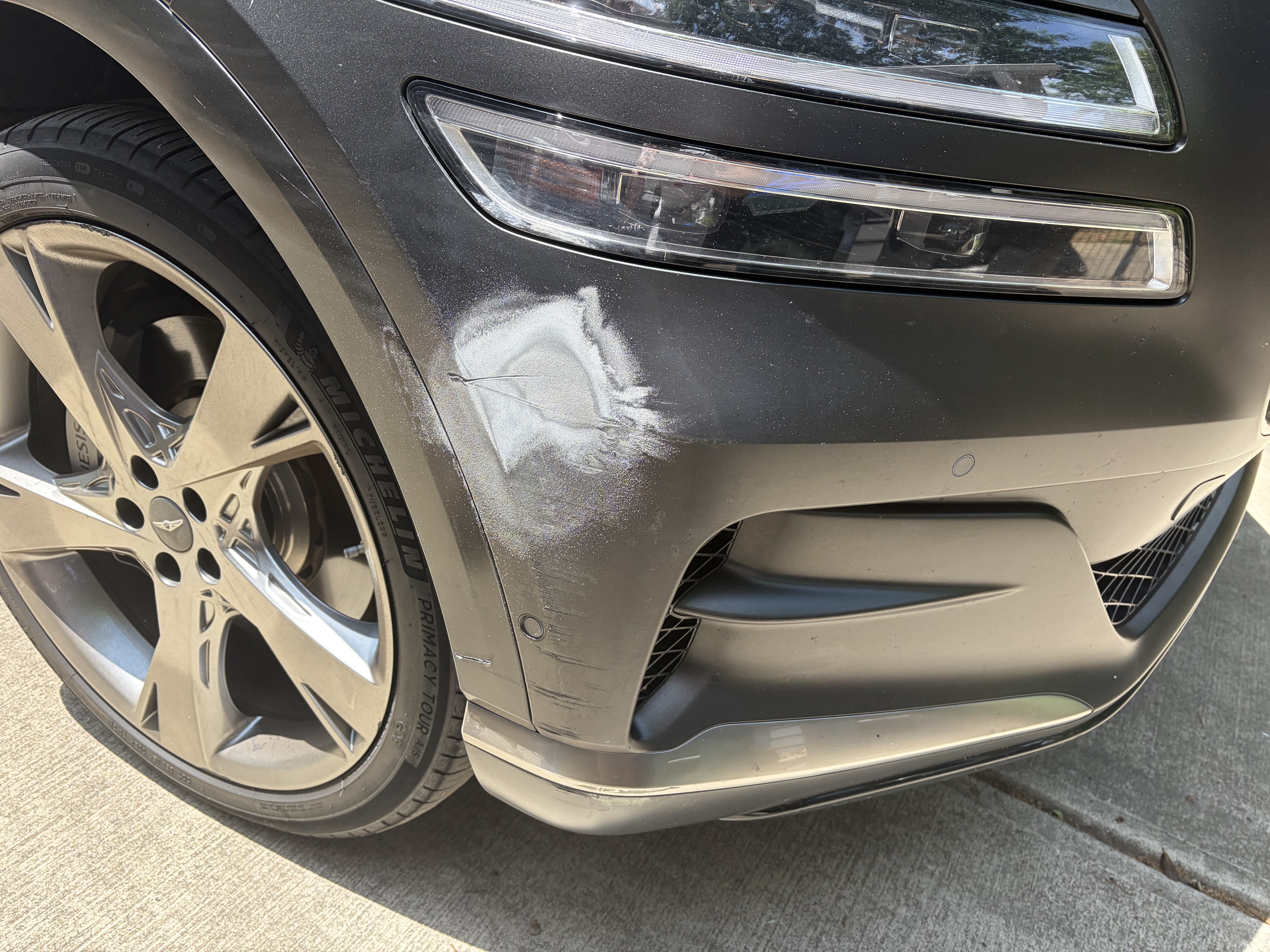 Genesis rear bumper with scratches and paint damage before repair